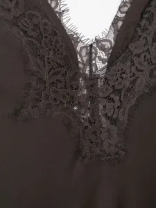 Close-up view of elegant dark satin and delicate lace V-neck trim detail for women dress.