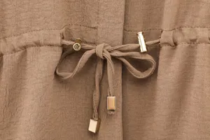 Close-up detail of women's casual drawstring waist with metal hardware and fabric tie.