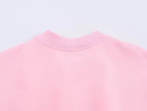 Détail de sweat-shirt décontracté rose gros plan, tissu doux et col ras du cou côtelé.
