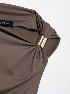 Close-up detail of women's asymmetric draped top with metallic ring and stretch fabric.