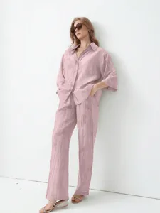 Vue détaillée de la chemise ample rose en jacquard et du pantalon de loisir assorti.
