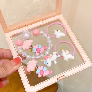 Detail view of cute children unicorn hair ties and pearl bracelet set in sweet pink design.