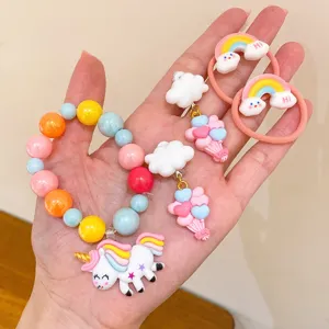 Close-up detail of cute unicorn bracelet and rainbow hair tie set for children jewelry.