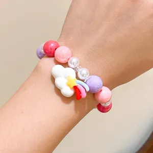 Close-up of children's colorful beaded bracelet featuring cute cloud and rainbow charm.