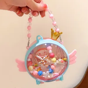 Kids DIY beaded transparent capsule toy handbag with cute angel wings and crown decoration.