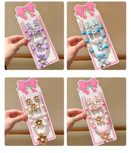 Close-up details of children's daisy pearl necklace and earrings set with cute bow card.