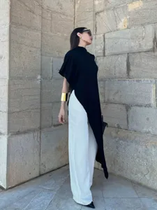 Asymmetric sleeveless high collar top detail view, showing pleated texture and unique hem.