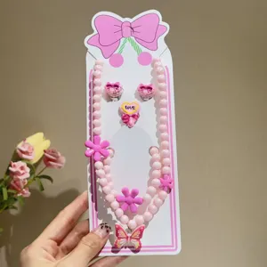 Detailed view of children's pink pearl necklace, earrings, ring, and bracelet 5-piece set.