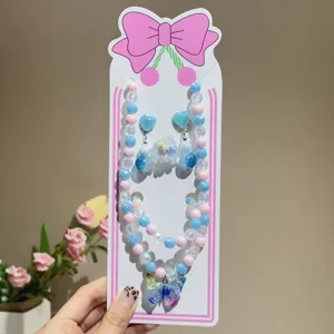 Children jewelry set featuring pink and blue beaded necklace, bracelet, earrings and ring.