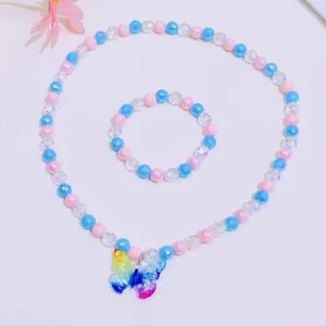 Close-up detail of children colorful beaded necklace and bracelet set with butterfly pendant.
