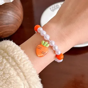 Kids cute pearl bracelet with carrot pendant, children wrist jewelry main display photo.