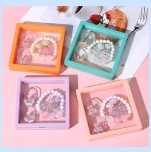 Detailed view of kids ocean style pearl bracelet and hair accessories set in floating display box.