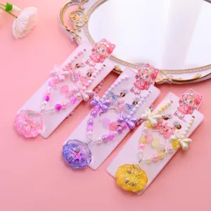 Detail shot of children ocean style shell pearl necklace bracelet jewelry set with cute cartoon card.