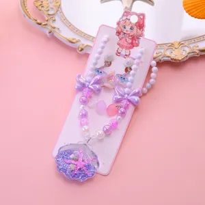Detail view of girls ocean style shell necklace bracelet earrings set with cute pink beads.