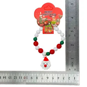 Detailed view of Christmas beaded bracelet with Santa pendant and holiday card packaging.