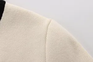 Nahaufnahme der feinen Stricktextur und sauberen Schulternaht der Damenbekleidung.