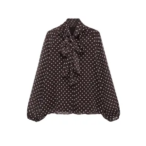 Detailed view of brown polka dot chiffon blouse with elegant bow tie collar and long sleeves.