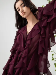 Close-up detailed view of women's elegant deep red V-neck layered ruffle long sleeve shirt fabric.