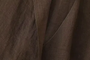 Brown linen fabric detail showing fine texture and stitching craft for apparel design close up