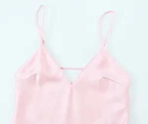 Détail de robe nuisette en satin rose, col V élégant avec fines bretelles spaghettis.