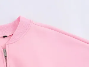 Détail du col et de l'épaule de veste rose, col côtelé, fermeture éclair en métal.