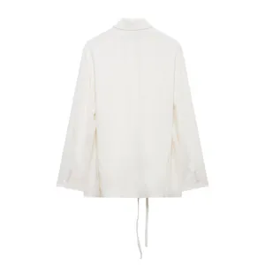 Détail de dos d'un blazer en mélange de lin blanc élégant avec cordon de serrage et boutons.