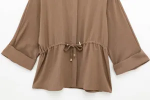 Casual women's brown long sleeve blouse detail featuring an adjustable waist drawstring and metal accents.