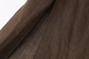 Brown linen fabric detail close-up showing natural woven texture and soft material quality.