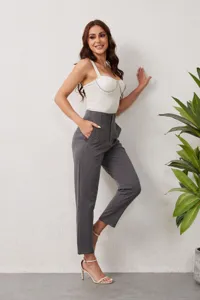 Detailed view of women's trendy white camisole and professional high waist grey trousers.
