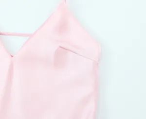 Détail de robe nuisette en satin rose, design élégant col en V, gros plan tissu lisse.