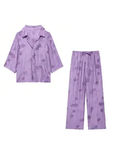 Vue détail du pyjama violet en jacquard fleuri avec une élégante chemise à revers et pantalon.