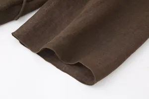 Detailed close-up of dark brown linen fabric showing fine texture and neat stitching.
