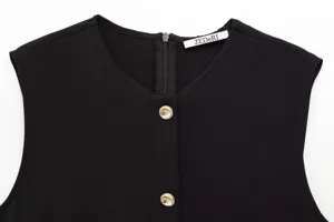 Detail view of black sleeveless dress collar featuring metal buttons and zipper.