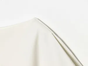 White women top shoulder detail close-up, premium smooth fabric, clean minimalist design.