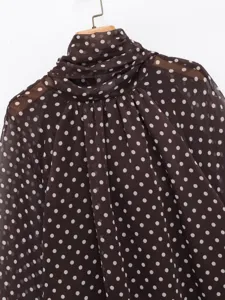 Detailed close-up view of women's dark brown polka dot chiffon blouse, mock neck style.