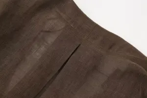 Detail view of brown linen pants featuring waist and slit design, premium fabric texture.
