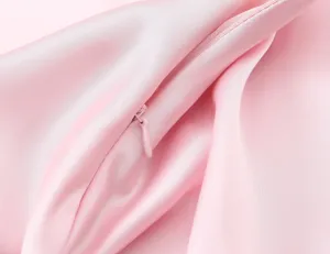 Vue détaillée de la robe midi en satin rose soulignant la texture lisse et la fermeture éclair.