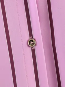 Detail shot of pink striped shirt fabric with elegant metallic button, fine texture.