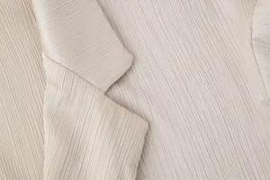 Primer plano detalle de tela de blazer elegante de mujer plisada, textura arrugada de moda