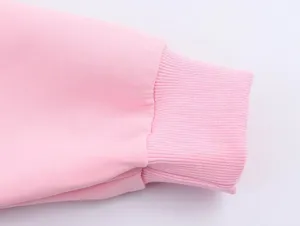 Gros plan sur le poignet côtelé rose, mettant en valeur la texture tricotée et extensible.