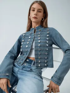 Korte denim jas voor dames met opstaande kraag en dubbele metalen knopen in detail.