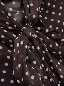 Chic brown polka dot blouse detail featuring an elegant bow tie collar and sheer chiffon fabric.