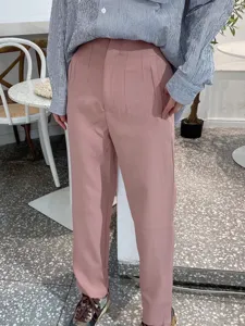 High waisted casual suit pants detail, pink women trousers fit display, indoor outfit view.