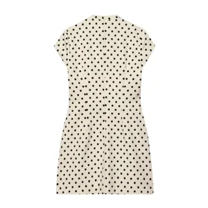 Elegantes, französisches kurzes Sommerkleid in Beige mit klassischem schwarzen Pünktchenmuster.