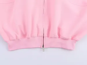 Vue détaillée de veste rose zippée, mettant en valeur la fermeture et l'ourlet côtelé.