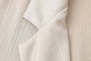 Primer plano detallado del tejido de la solapa del blazer arrugado de mujer, elegante.
