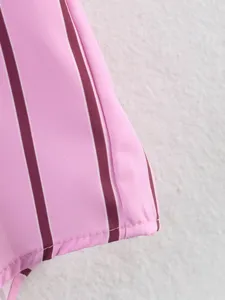 Close-up detail of women's pink striped shirt hem, showing fine stitching texture.