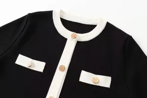 Elegante schwarze Kontrast-Strickjacke mit schicker weißer Biese und Knöpfen.