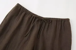 Detail view of women casual brown linen trousers featuring elastic waist with drawstring.