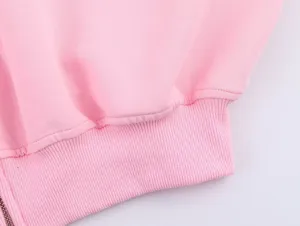 Gros plan de l'ourlet de sweat-shirt rose pour femmes avec fermeture éclair, tissu doux.